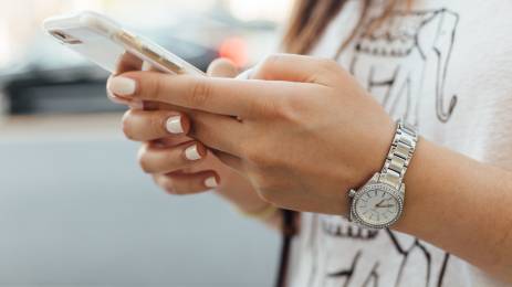 Kvinne med mobiltelefon i hendene