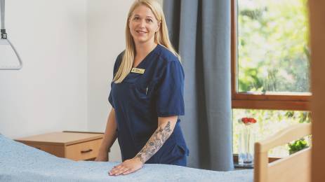 Sykepleier som står inne på et pasientrom