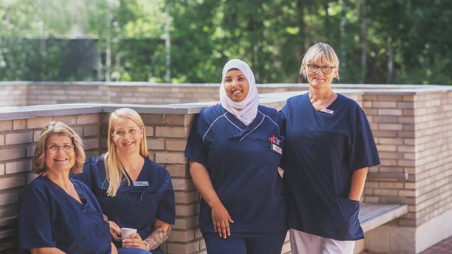 Fire sykepleiere som smiler utendørs