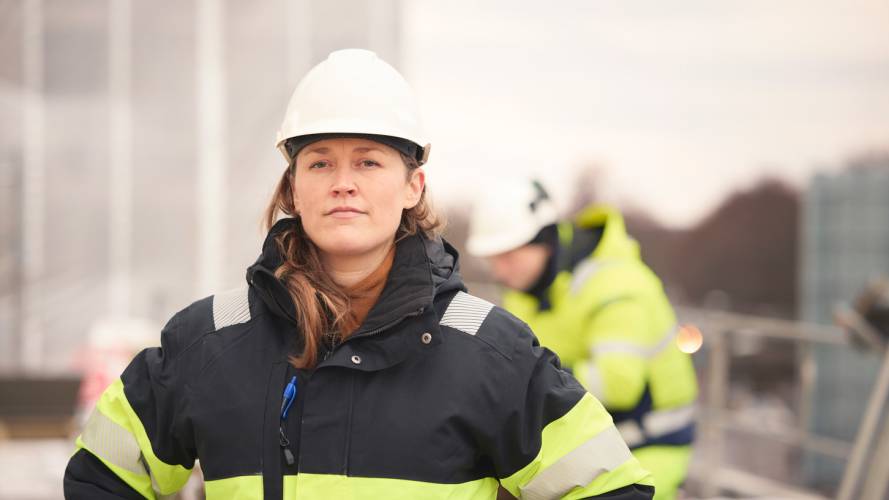 Dame i håndverkeruniform på byggeplass 