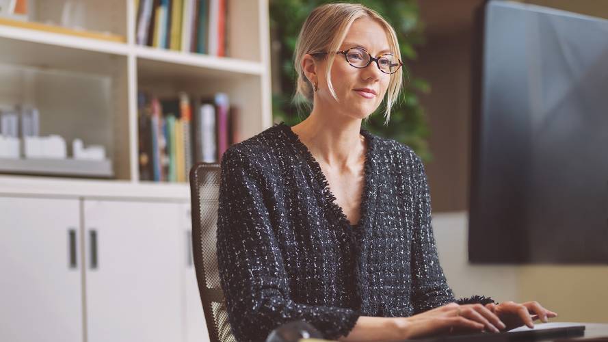 Dame med briller som jobber på pc