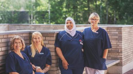 Fire sykepleiere som smiler utendørs