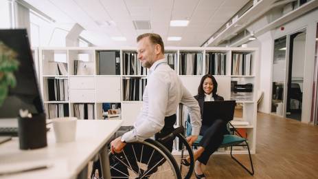 Mann i rullestol på kontor.