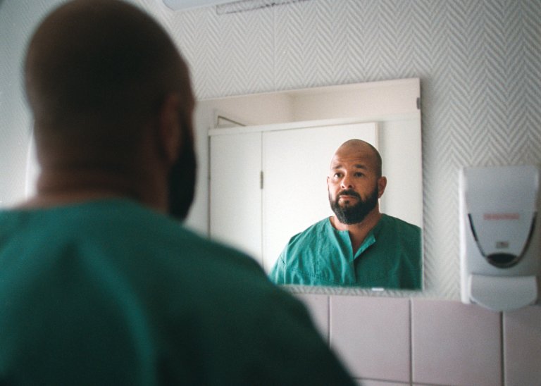 Sykehusansatt står foran et speil