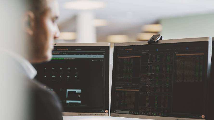 Mann som ser på ulike fond på pc